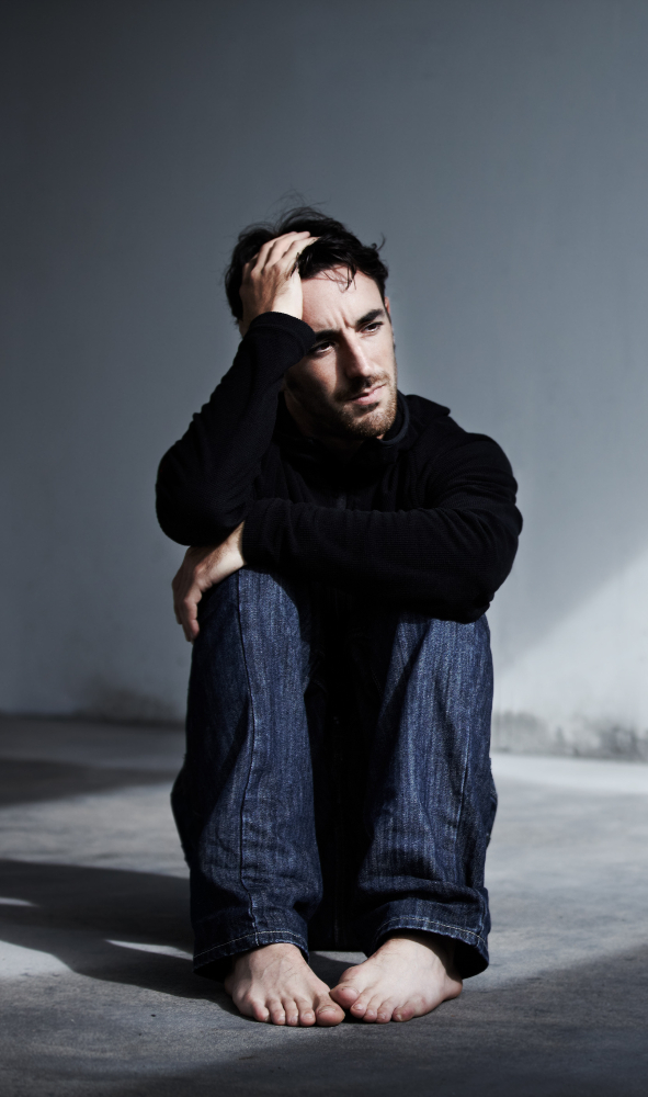 man sitting on floor in empty room struggling with schizoaffective disorder treatment