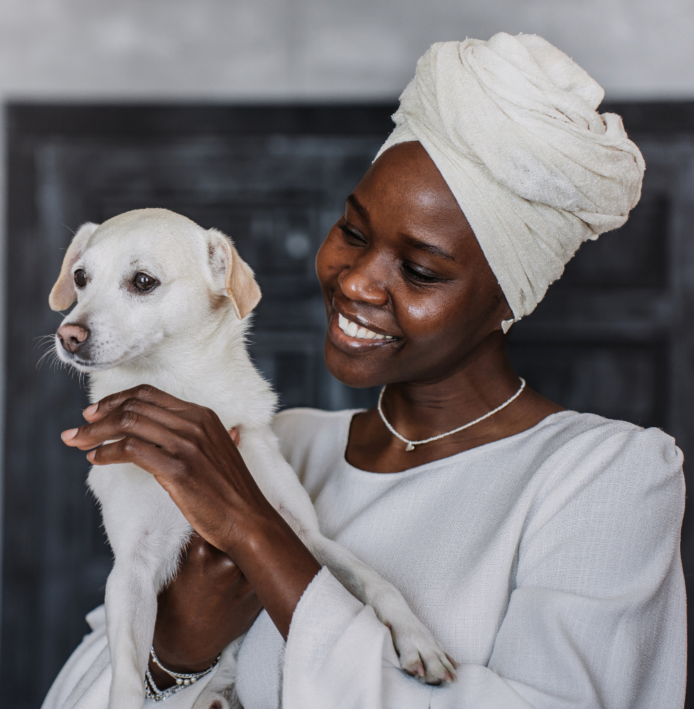 african woman smiling holding dog - pet friendly mental health facilities